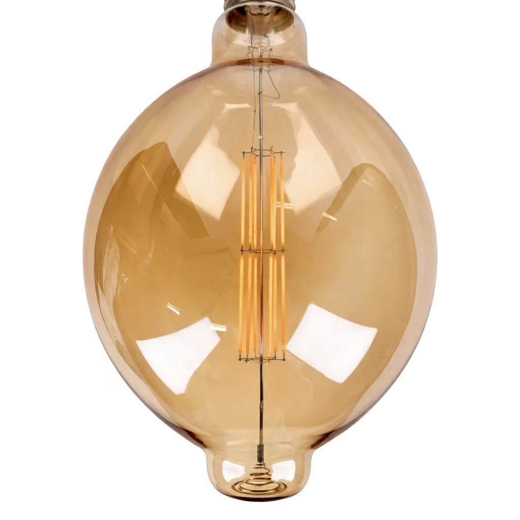 Close-up of the ceramic filament inside the amber large LED bulb on white background